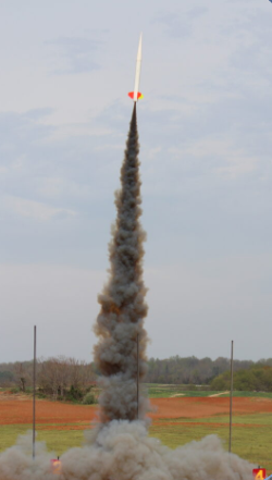 A team rocket ascending above a tall smoke trail